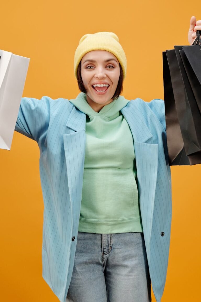 A Happy Woman Holding Paper Bags while Smiling at the Camera